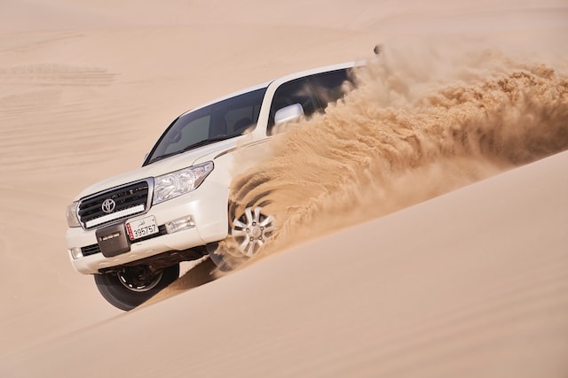 A vehicle dune bashing in a desert