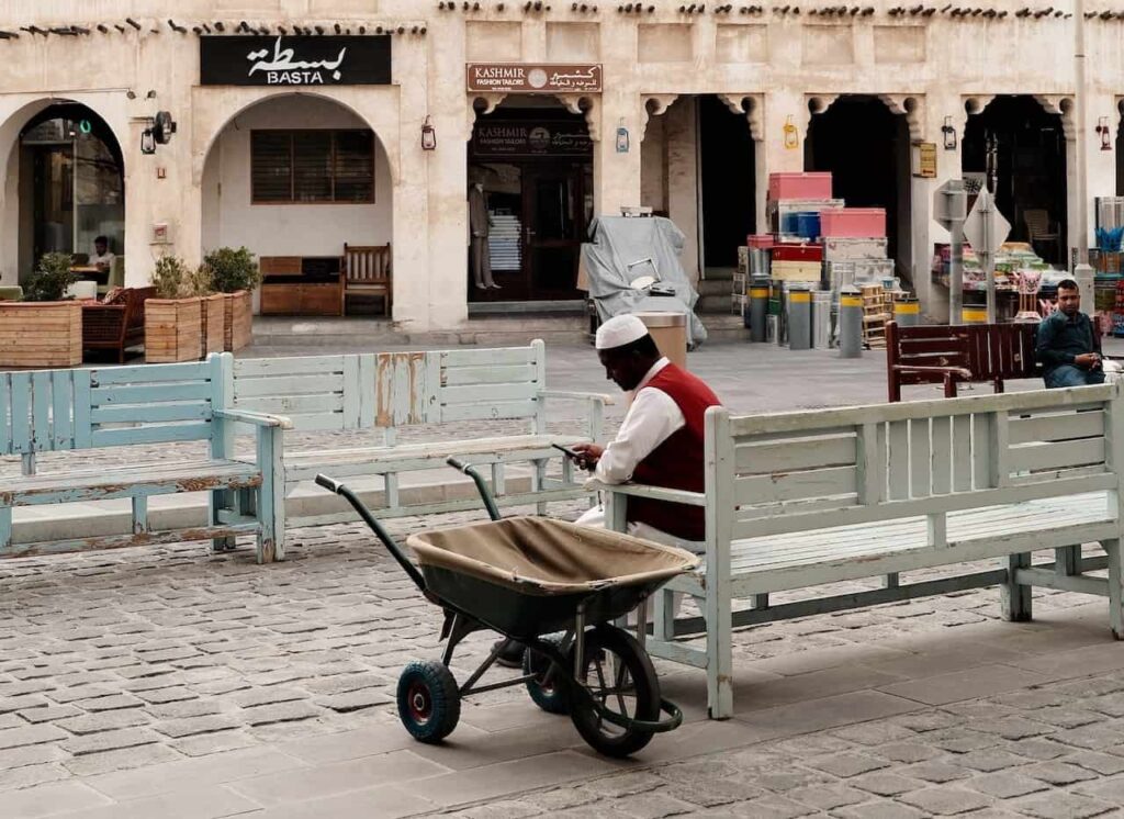 A hamali taking a rest with his wheelbarrow  out side the Souq Waqif 