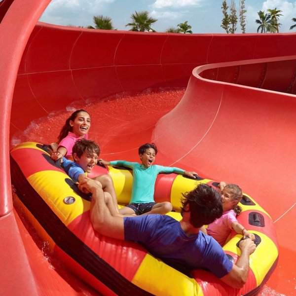 A family happily sliding in a water slider