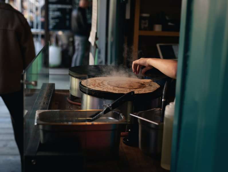 A woman making a crepe in souq waqif