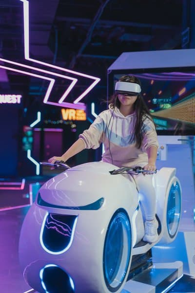 A woman riding a VR bike with VR helmet on.