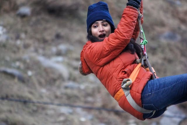 a woman excitingly ziplining