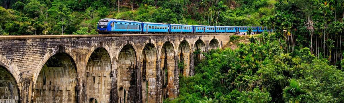 A blue colored train crossing over the Ella bridge