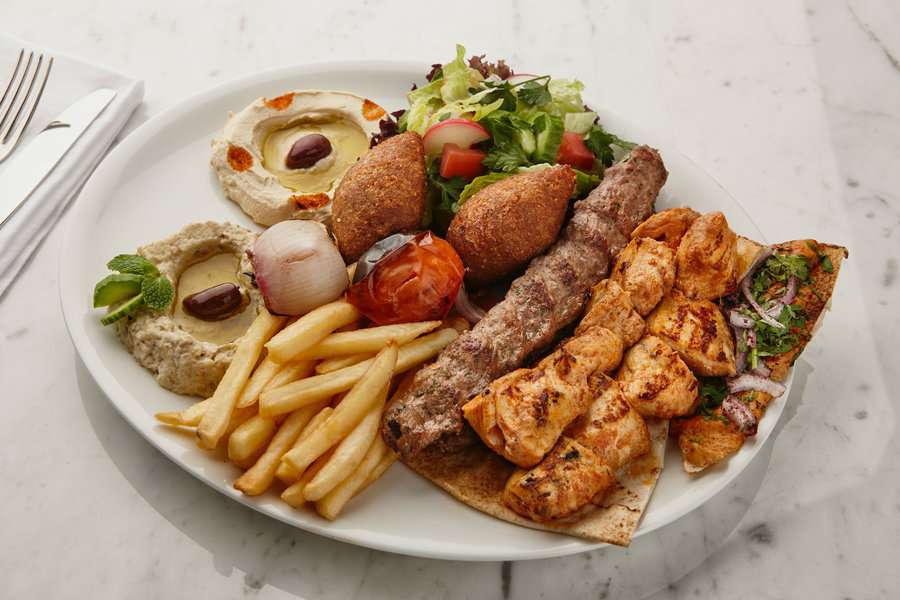 chicken and beef BBQ plate with chips and hummus