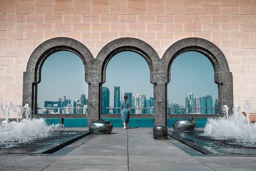 A woman standing in the Museum of Islamic Art with the backdrop of Doha city
