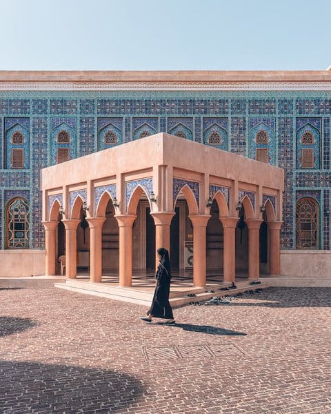 A woman walking infront of the Katara mosque Doha