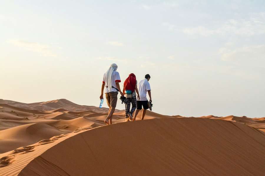 three men walking in the desert