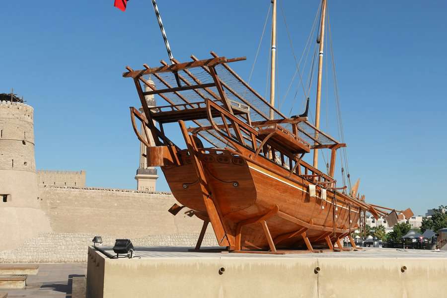 a traditional boat model displayed outside a museum