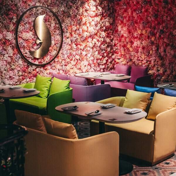 Inside view of Finch in kL with different color sofa sets and wall full of roses