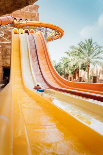 a boy is sliding in the water park